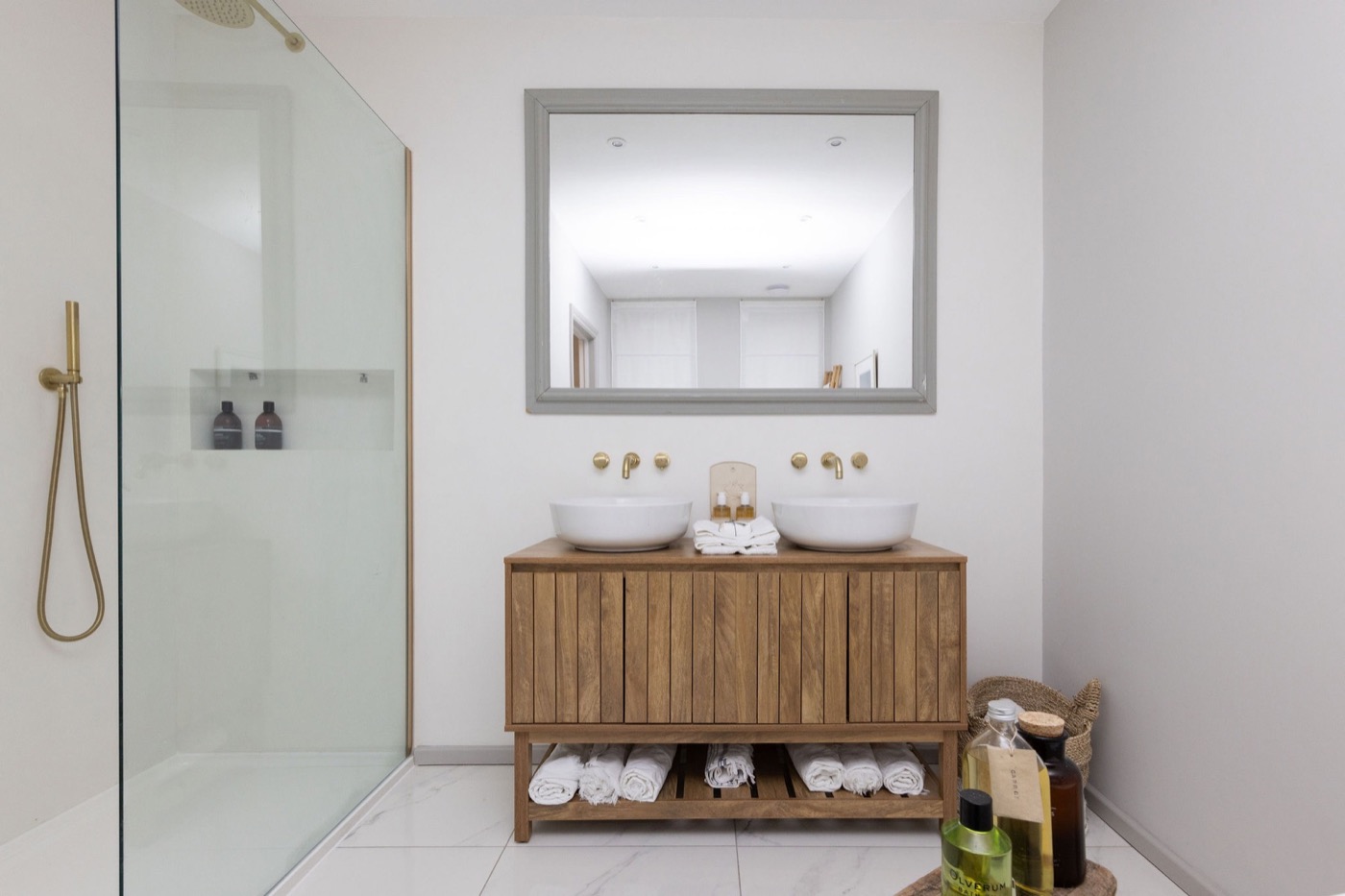 Twin-basin bathroom with brass fittings and oak vanity at The Lookout Brighton