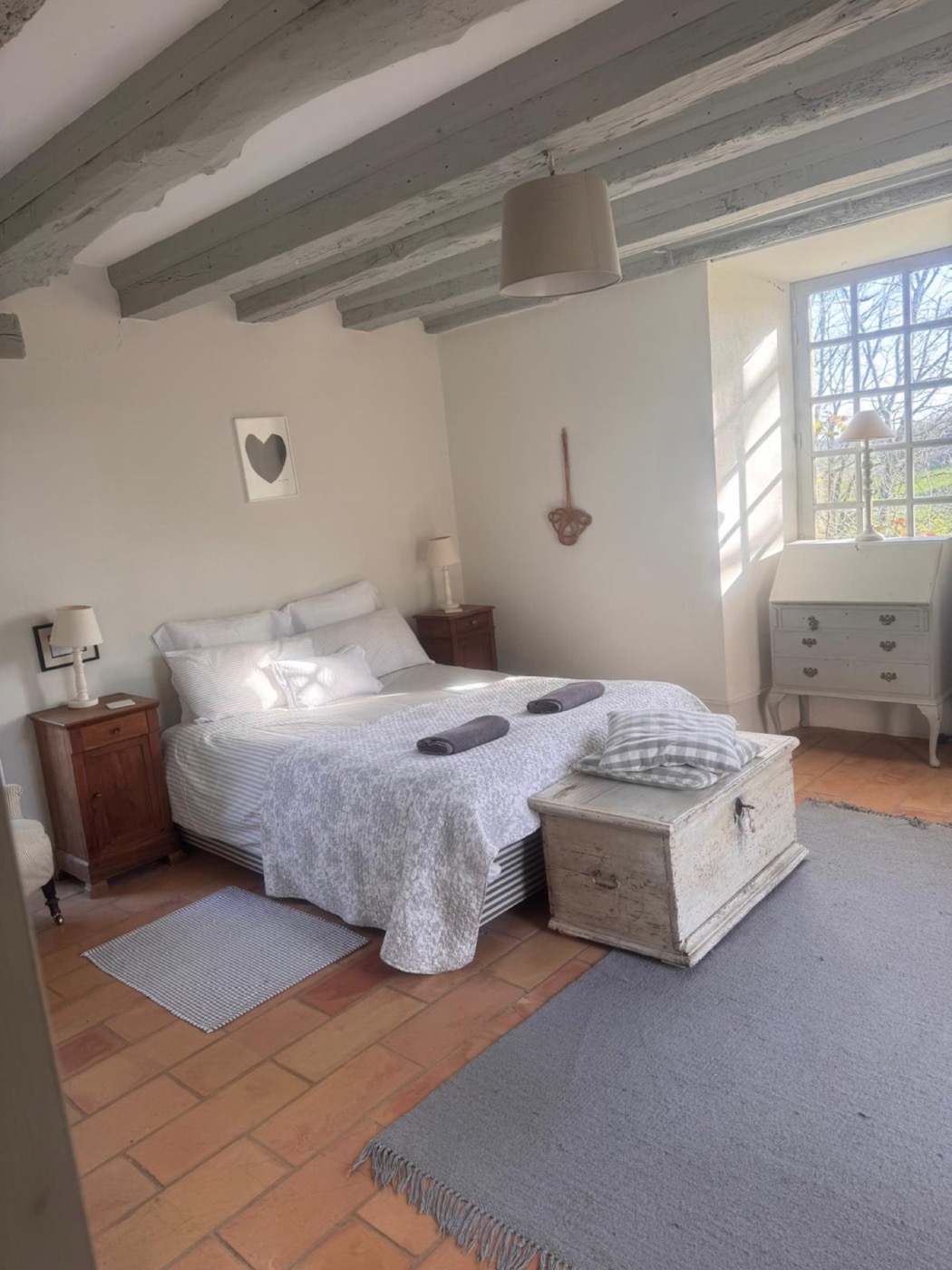 Calm double bedroom with original beams and terracotta floor